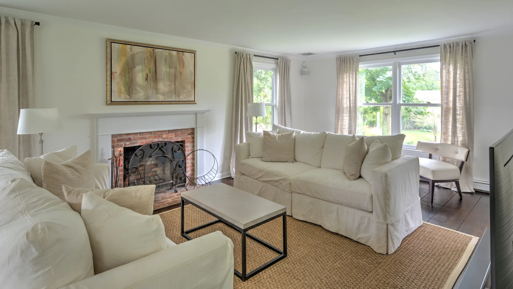 Una sala luminosa con asientos claros y una chimenea.