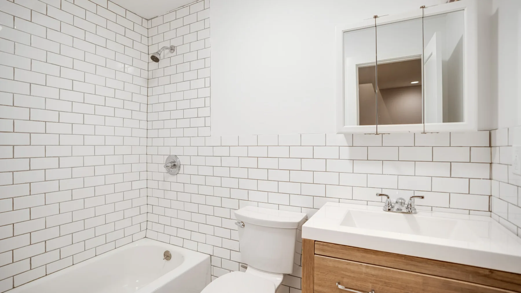 Un baño alicatado con bañera, inodoro y lavabo.