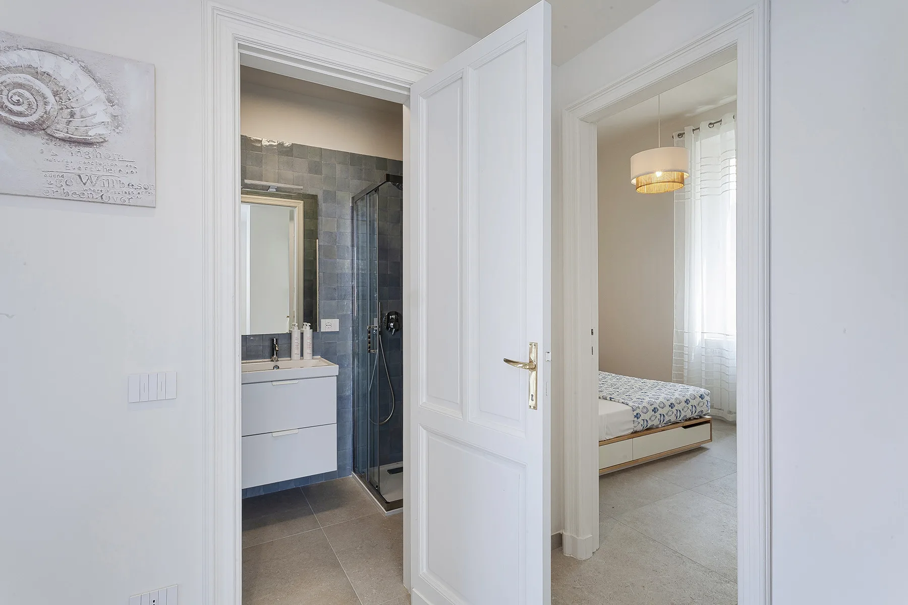 Un pasillo luminoso da acceso a un baño y un dormitorio.