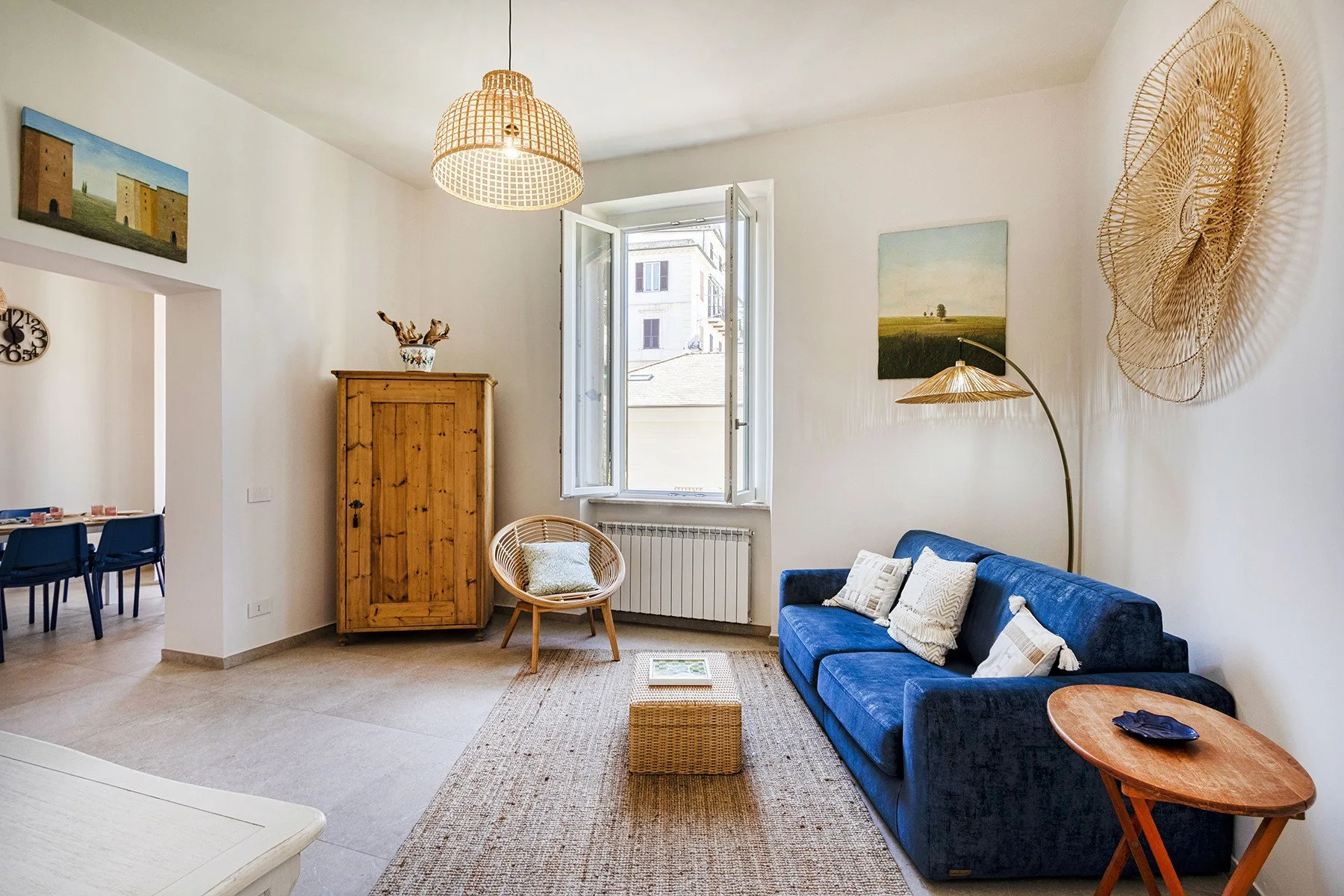 Una sala luminosa con asientos azules junto a una ventana abierta.