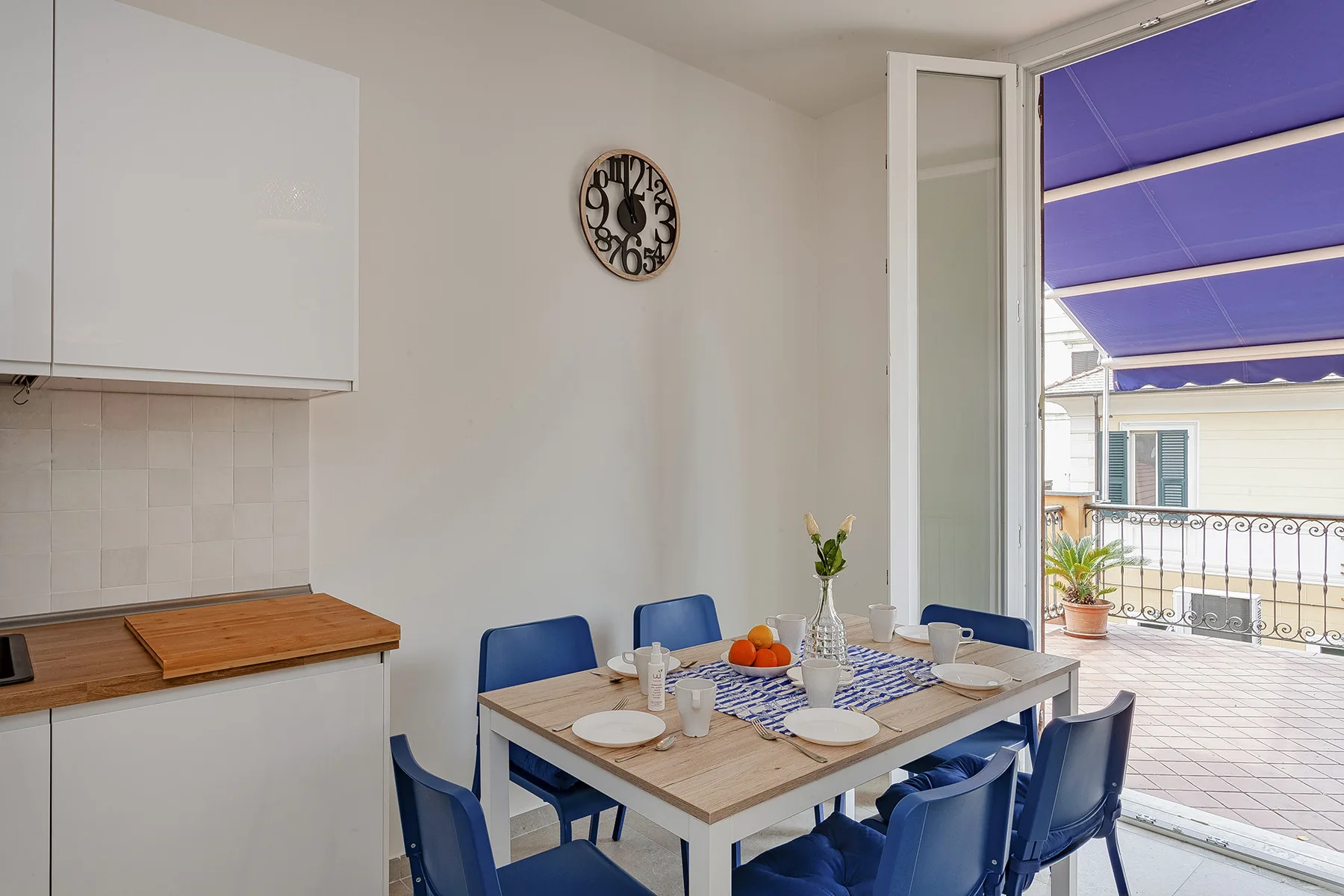 Un comedor con una mesa junto a una puerta abierta al balcón.