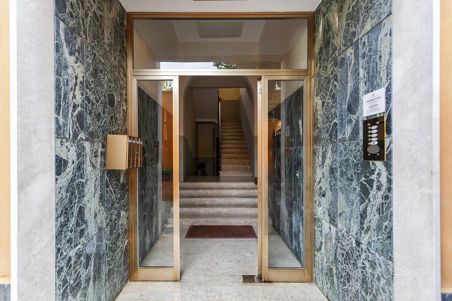 Una entrada con puertas de vidrio da a una escalera interior.