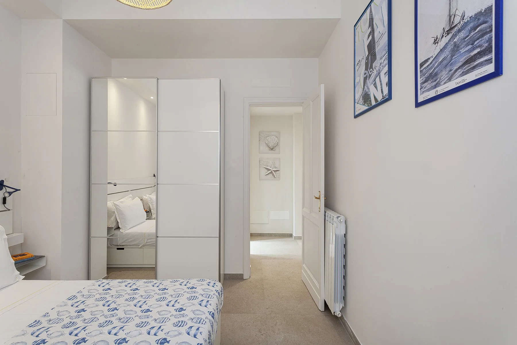 Un dormitorio con una cama, un armario con espejo y una puerta abierta.