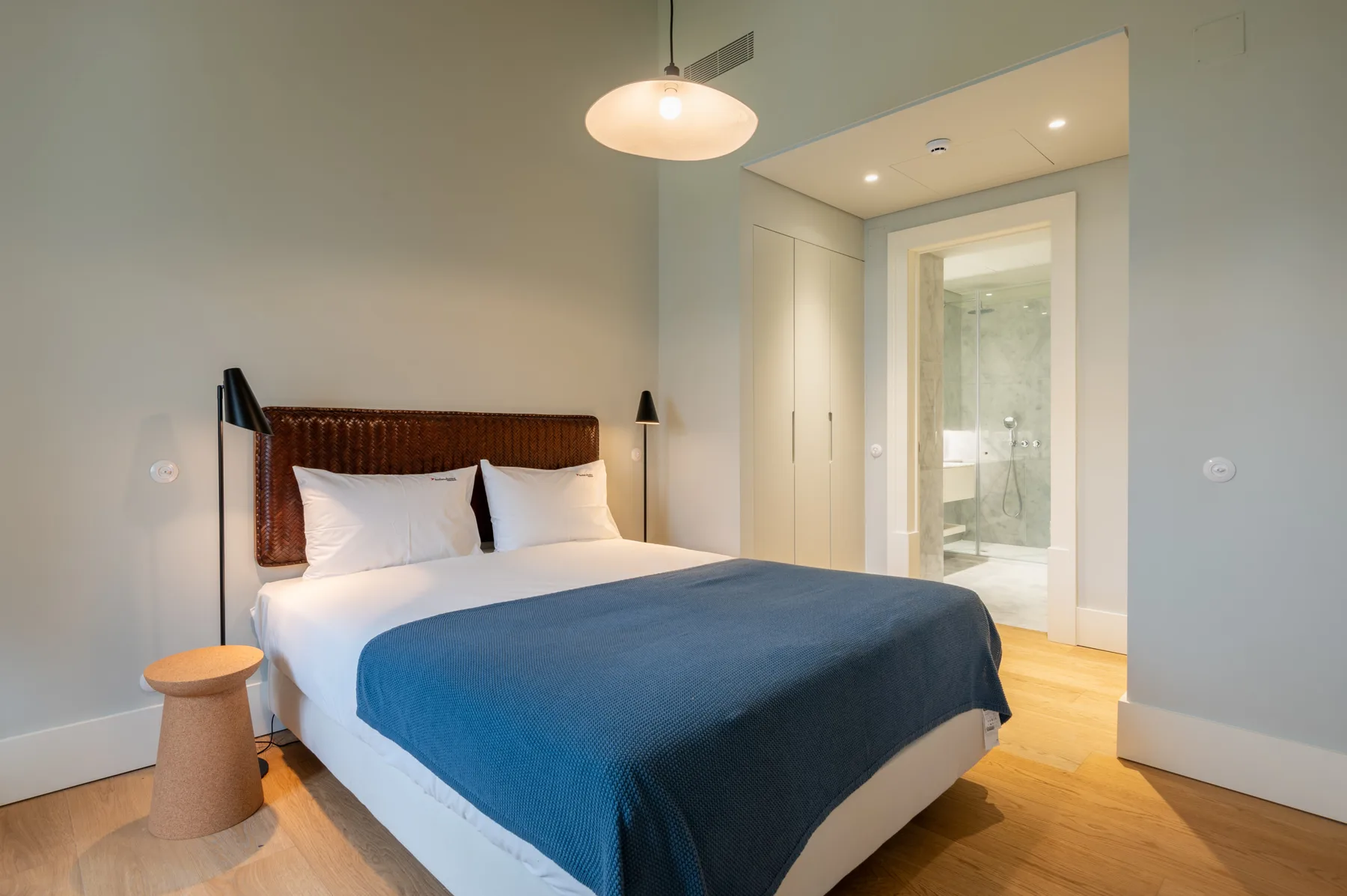 A bedroom with a bed and an open doorway to a bathroom.