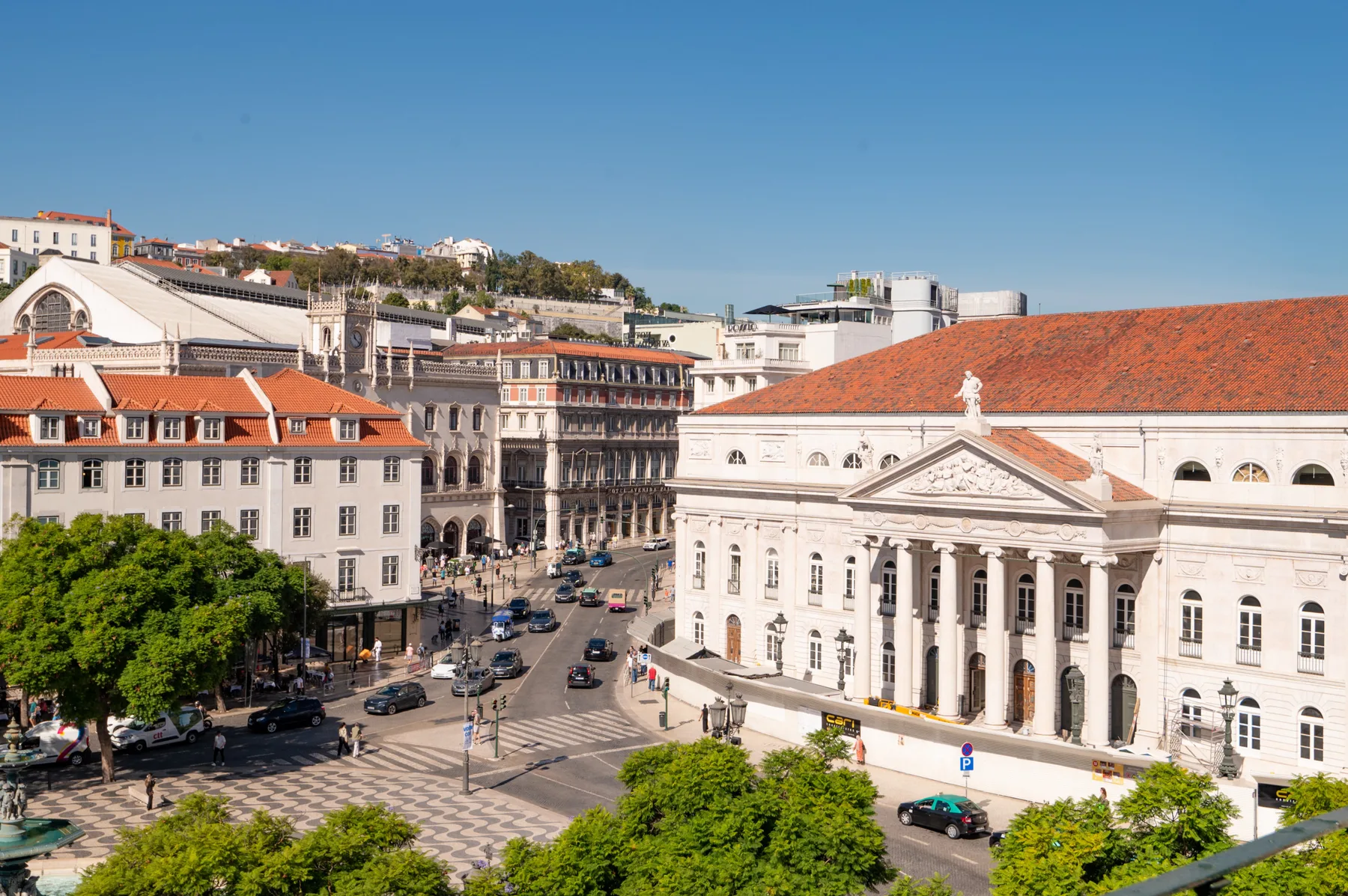 A city square with a large neoclassical building, surrounding streets, and trees.