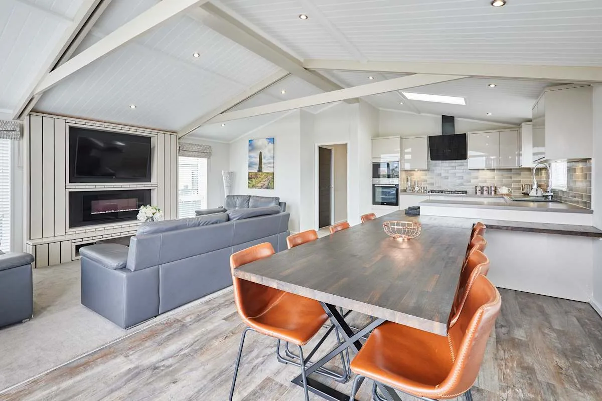 An open-plan living and dining area with a kitchen and a large dining table.