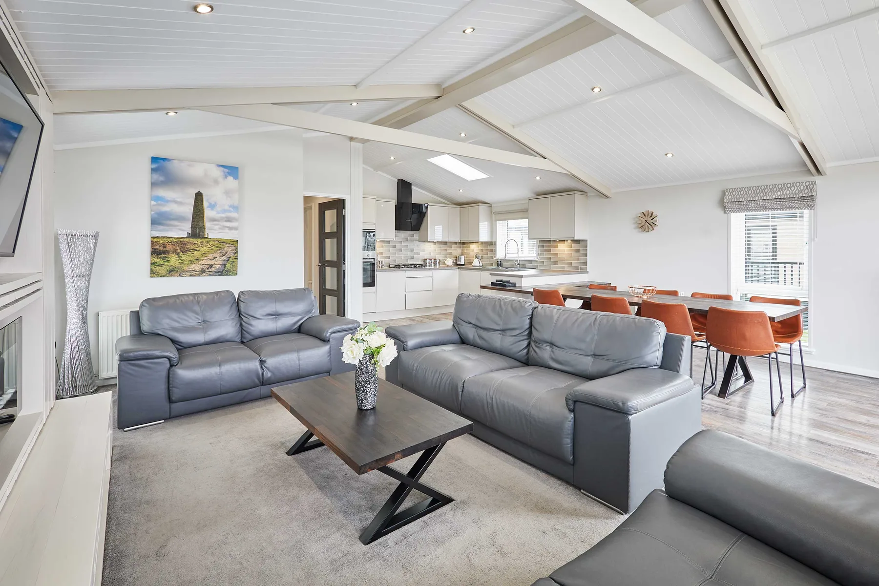 An open-plan living and dining area with gray seating and a dining table.