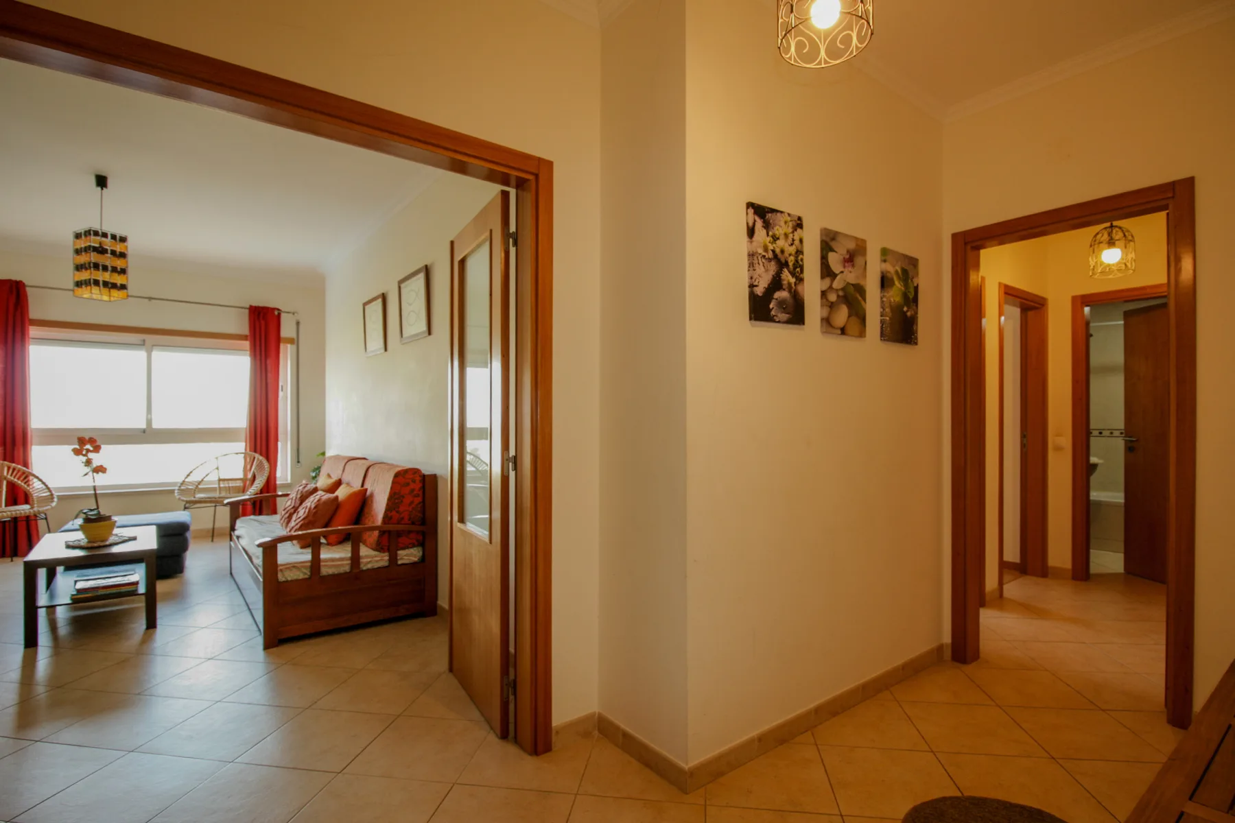 Un interior cálido muestra un pasillo junto a una sala de estar con asientos.