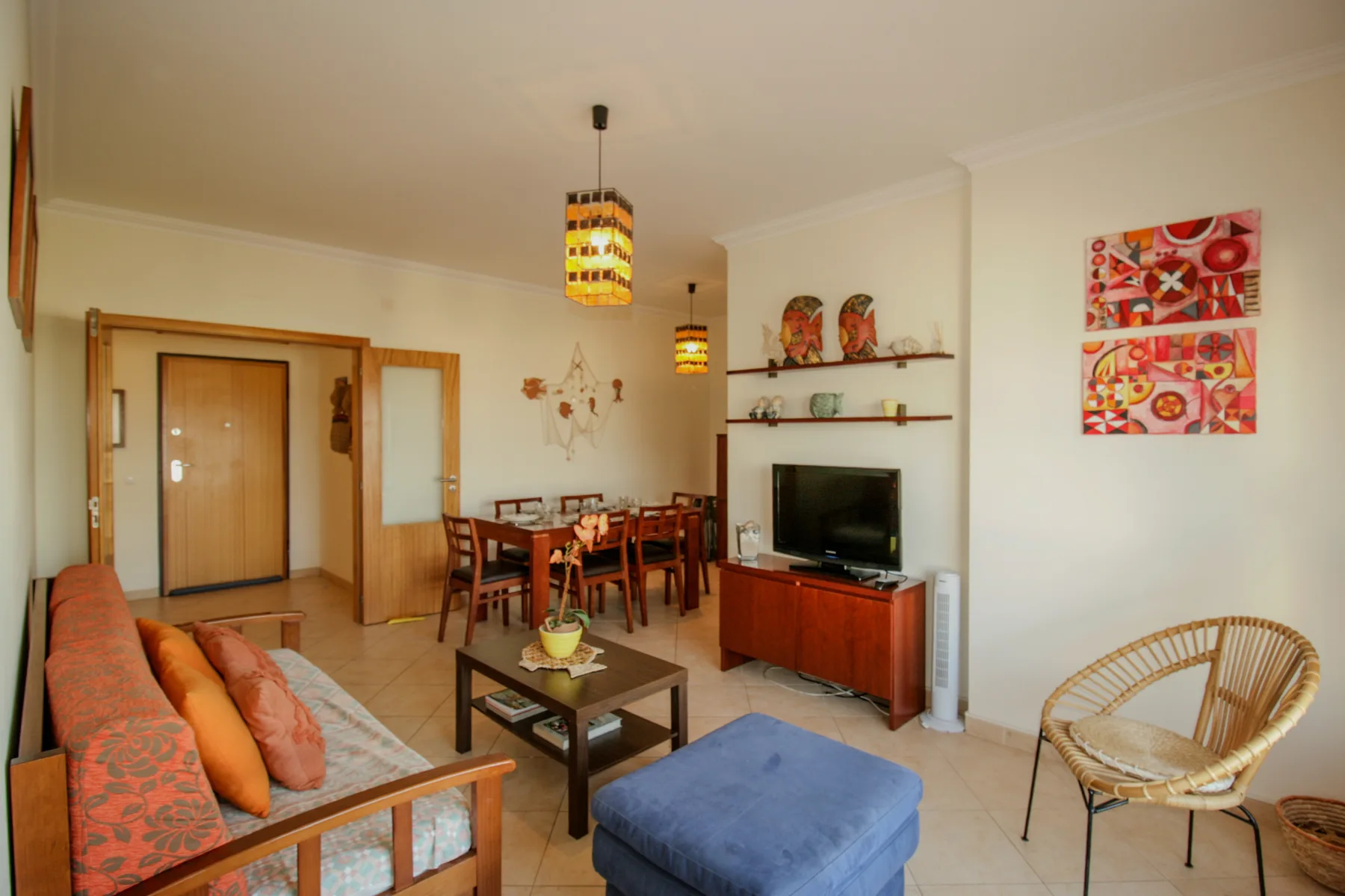 Living room with seating, a dining area, and a television.