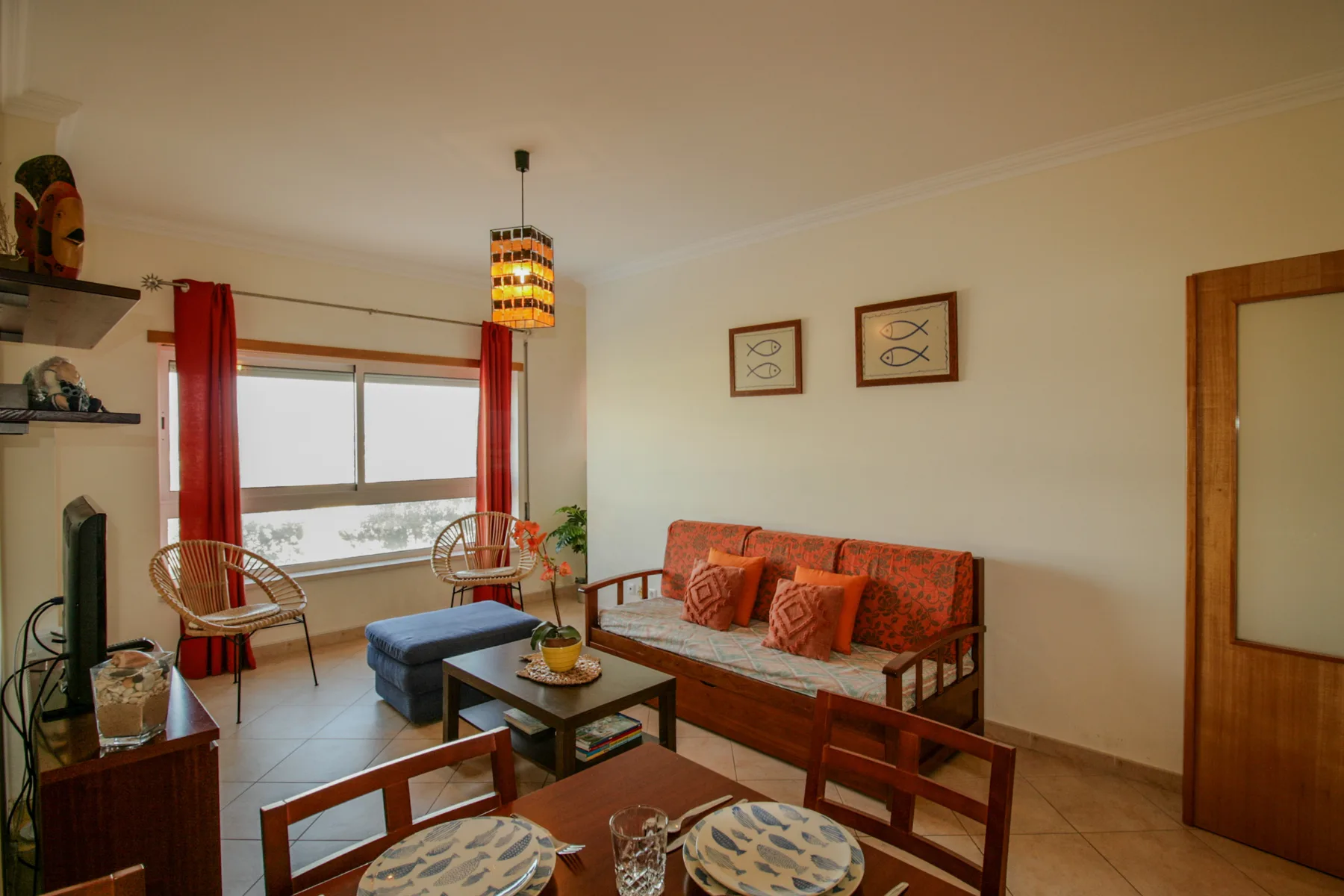 Sala de estar con asientos alrededor de una mesa de centro junto a una ventana.