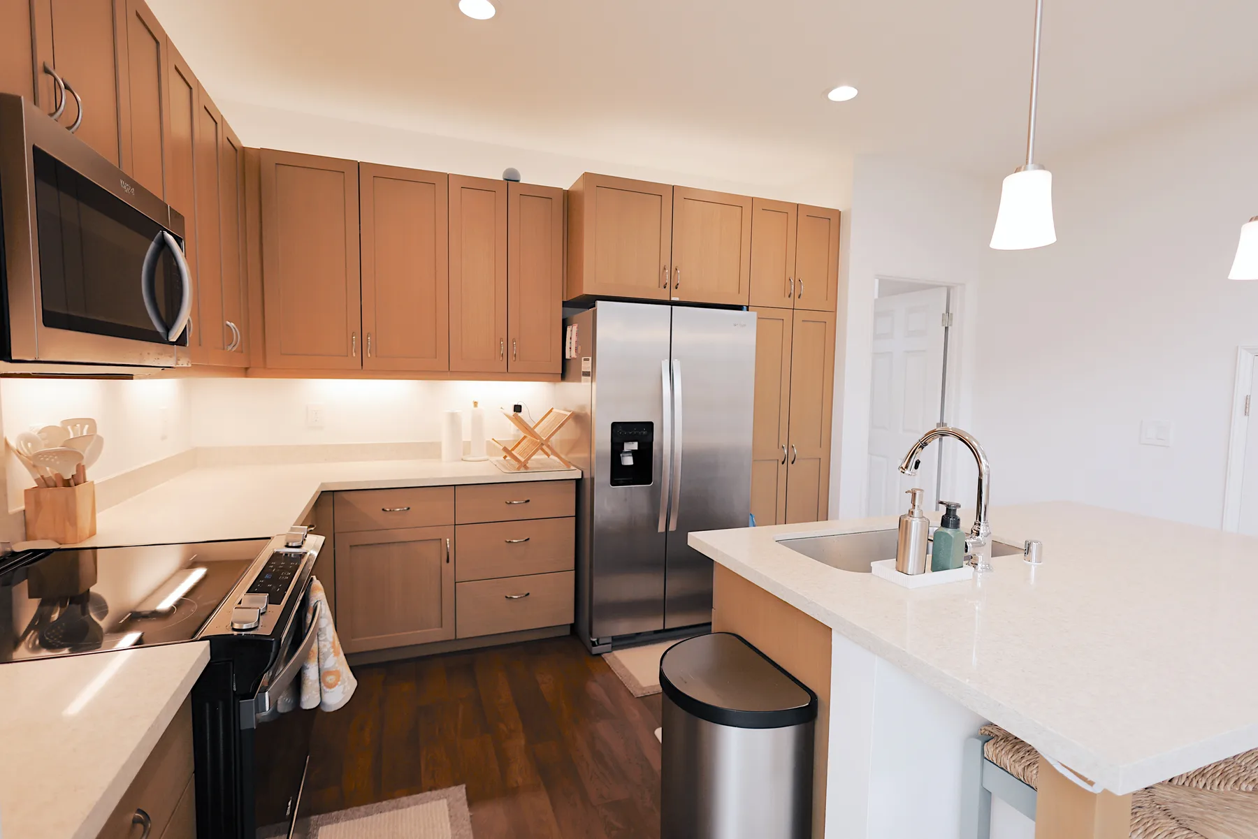 A bright kitchen with warm wood cabinets, stainless steel appliances, and a large island.