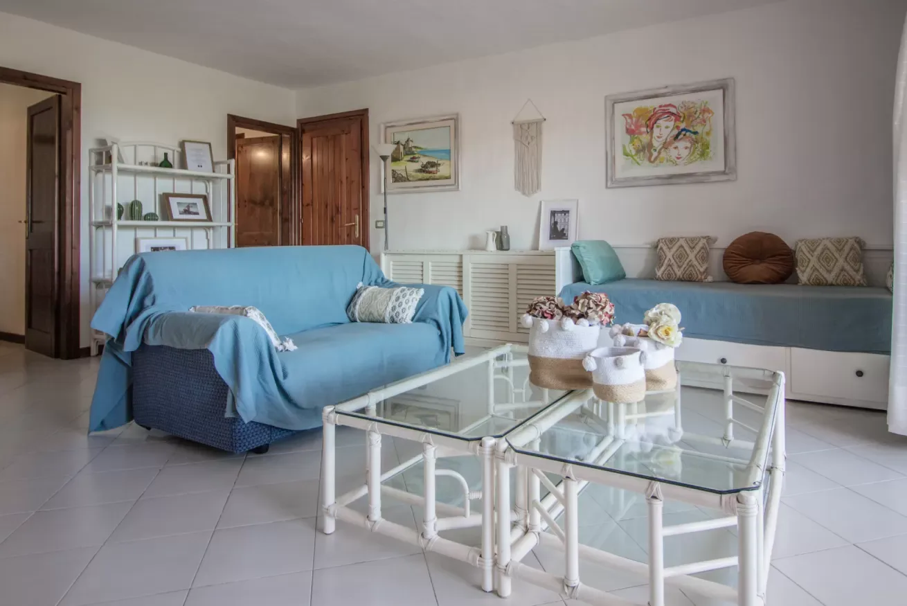 A living room with blue seating and a glass coffee table.
