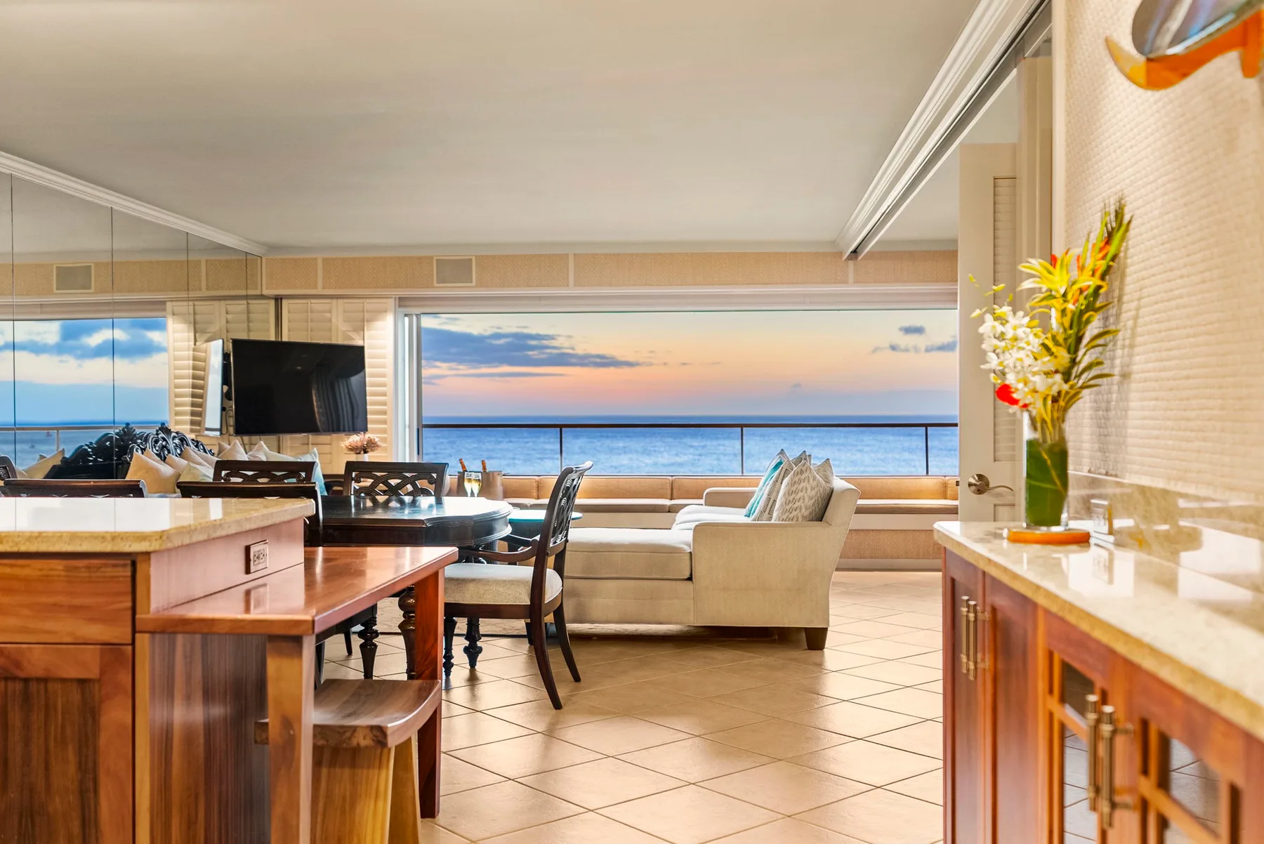 Una sala y comedor se abren a una amplia vista al mar a través de grandes ventanas.