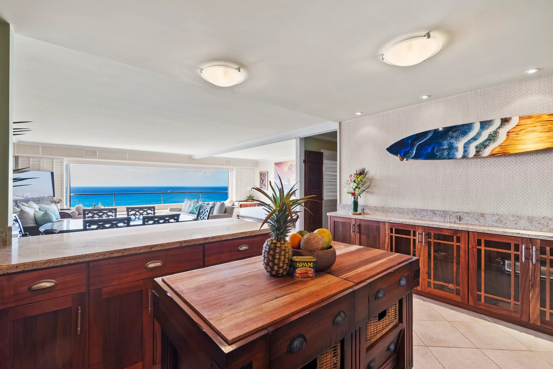 Una cocina con una isla de madera y una amplia ventana con vistas al océano.