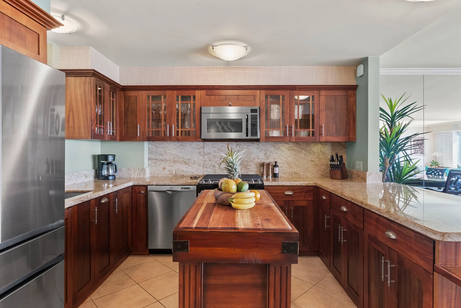Una cocina con gabinetes de madera, electrodomésticos de acero inoxidable y una isla central.