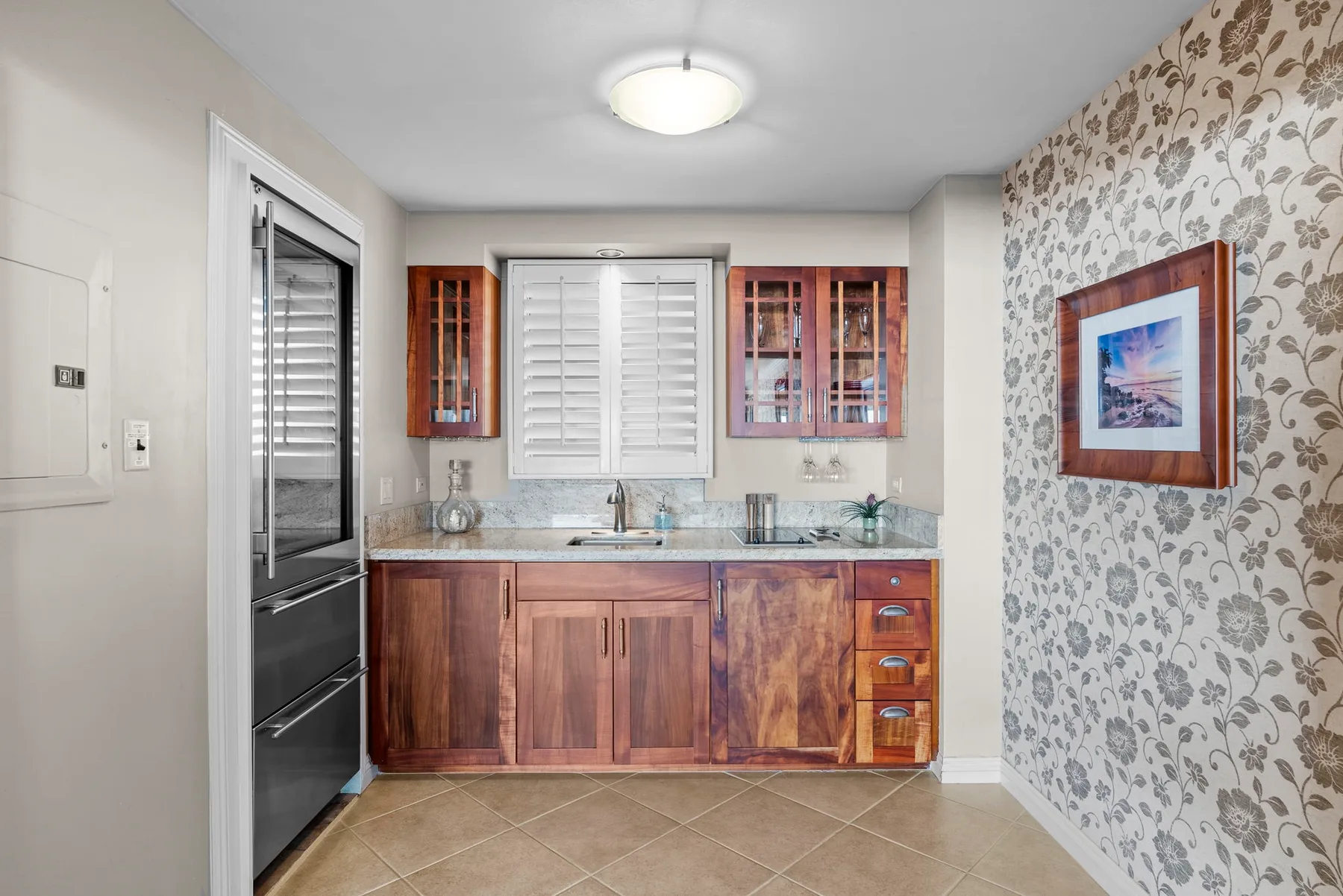Una pequeña cocina con gabinetes de madera, fregadero y horno empotrado.