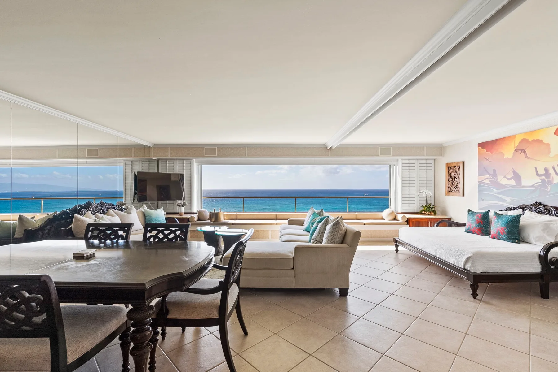 Una sala luminosa se abre a una amplia vista al mar a través de grandes ventanales.