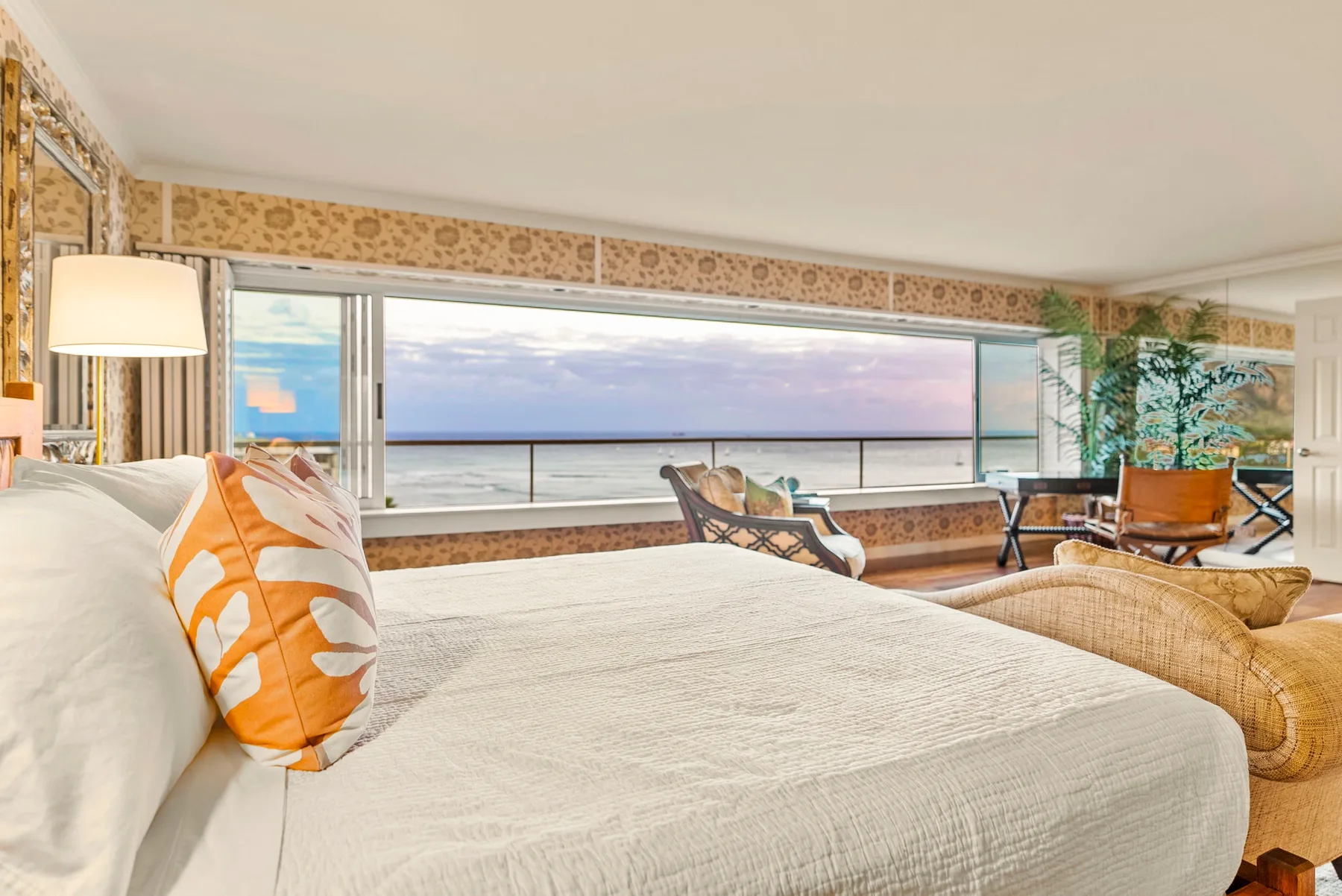 Un dormitorio se abre a una amplia vista al mar a través de grandes ventanales.