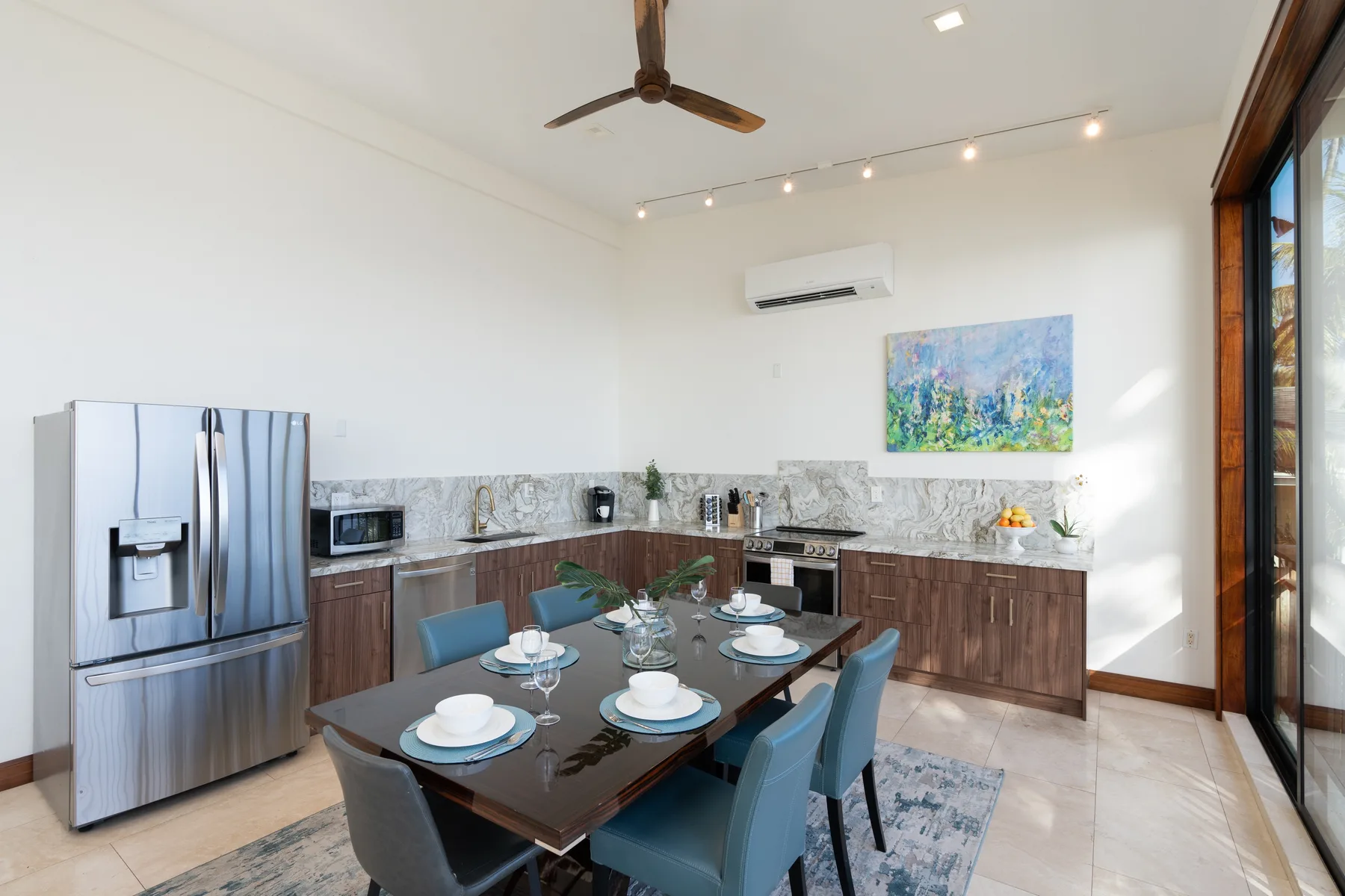 A dining table sits in a bright open kitchen with wooden cabinets.