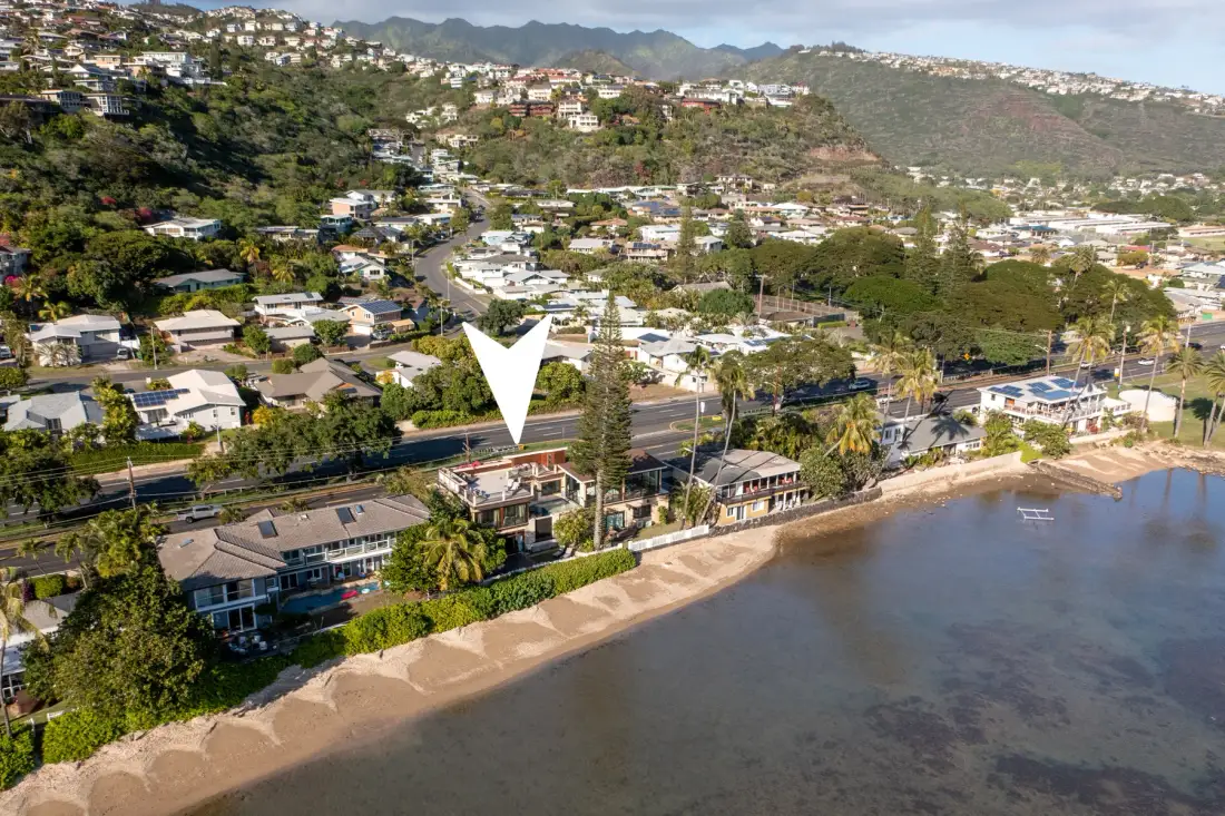 An aerial view of a coastal neighborhood with homes along the beach.