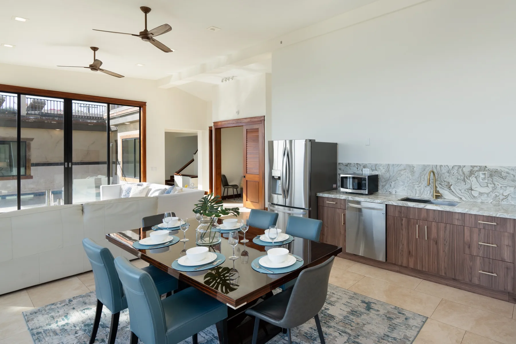 A dining area with a table beside a kitchen and large sliding glass doors.