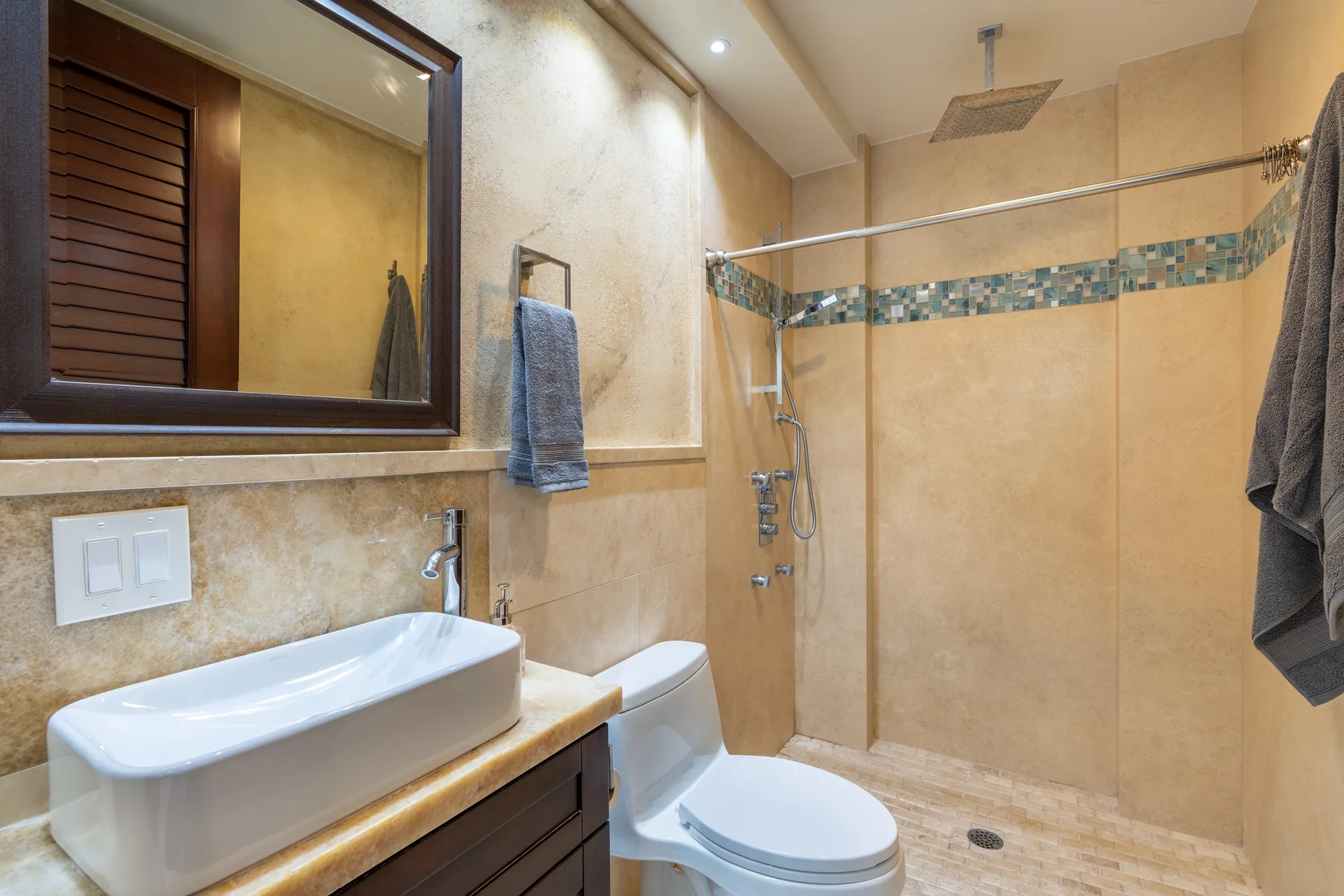 A bathroom with a sink, toilet, and glass-enclosed shower.