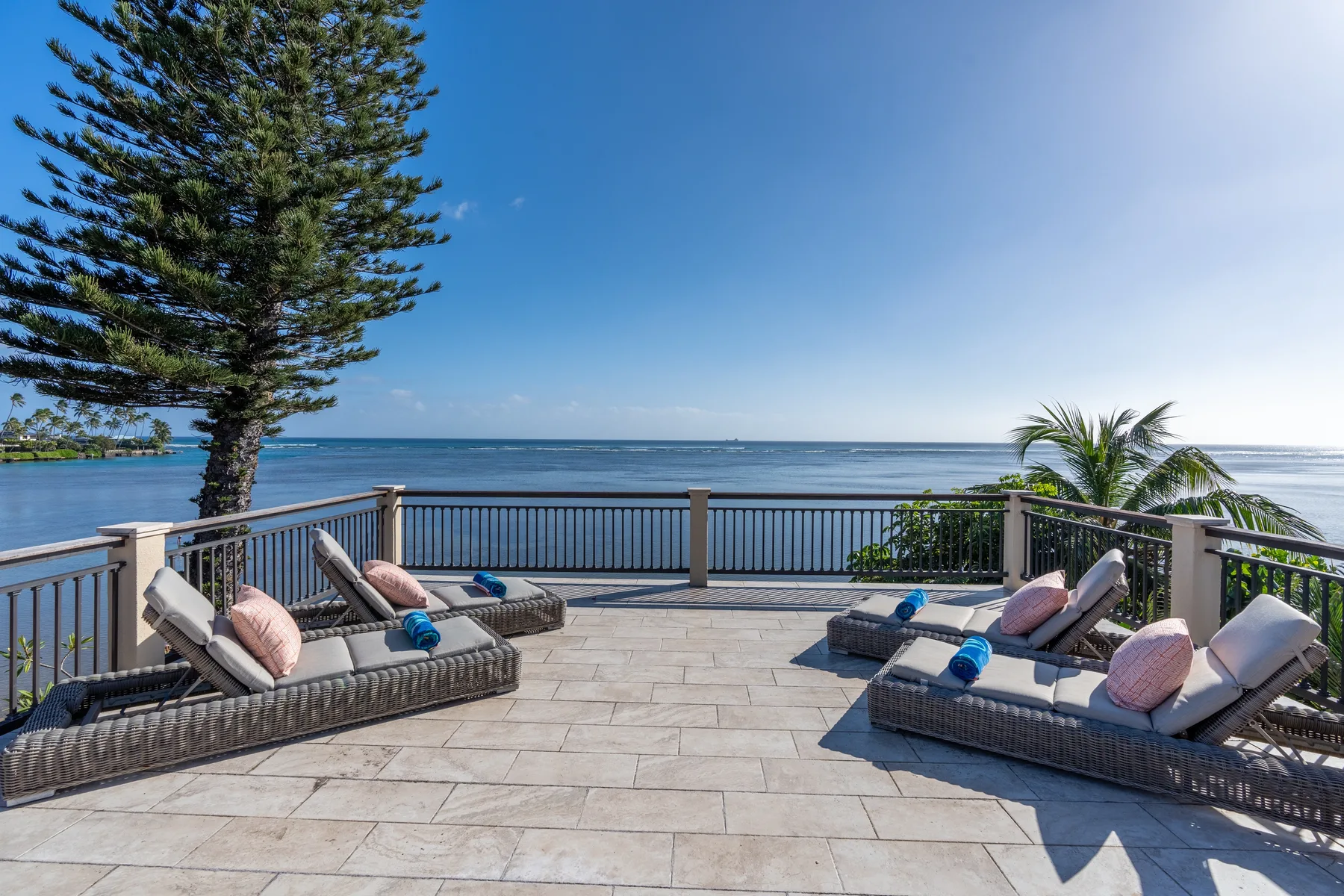 A seaside terrace with lounge seating overlooks the ocean.