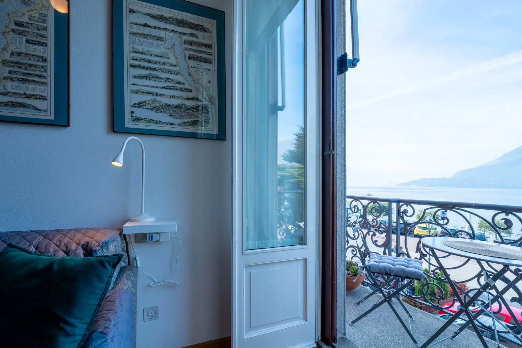 Un dormitorio da a un balcón con barandilla decorativa y vistas al agua.