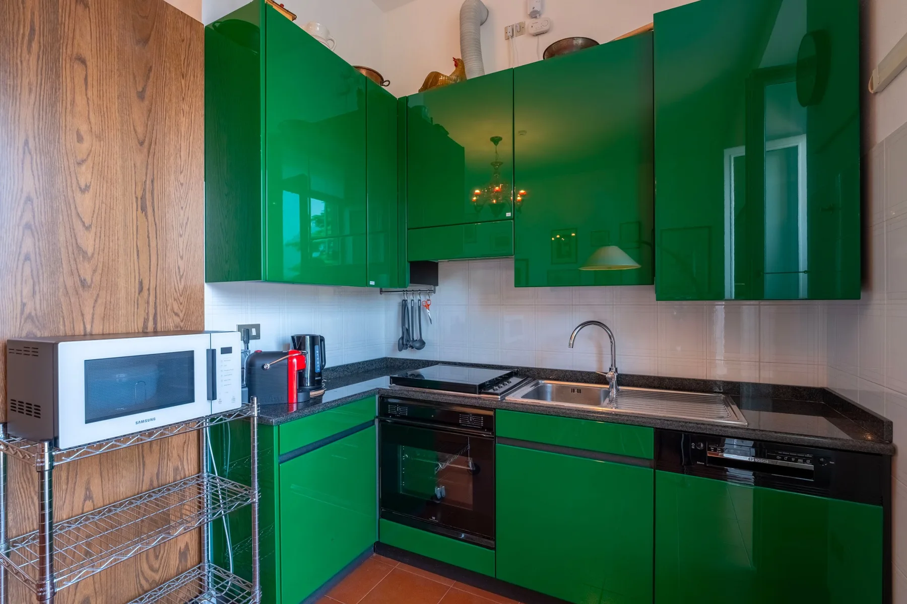 Una cocina con gabinetes verdes, una encimera y un fregadero.