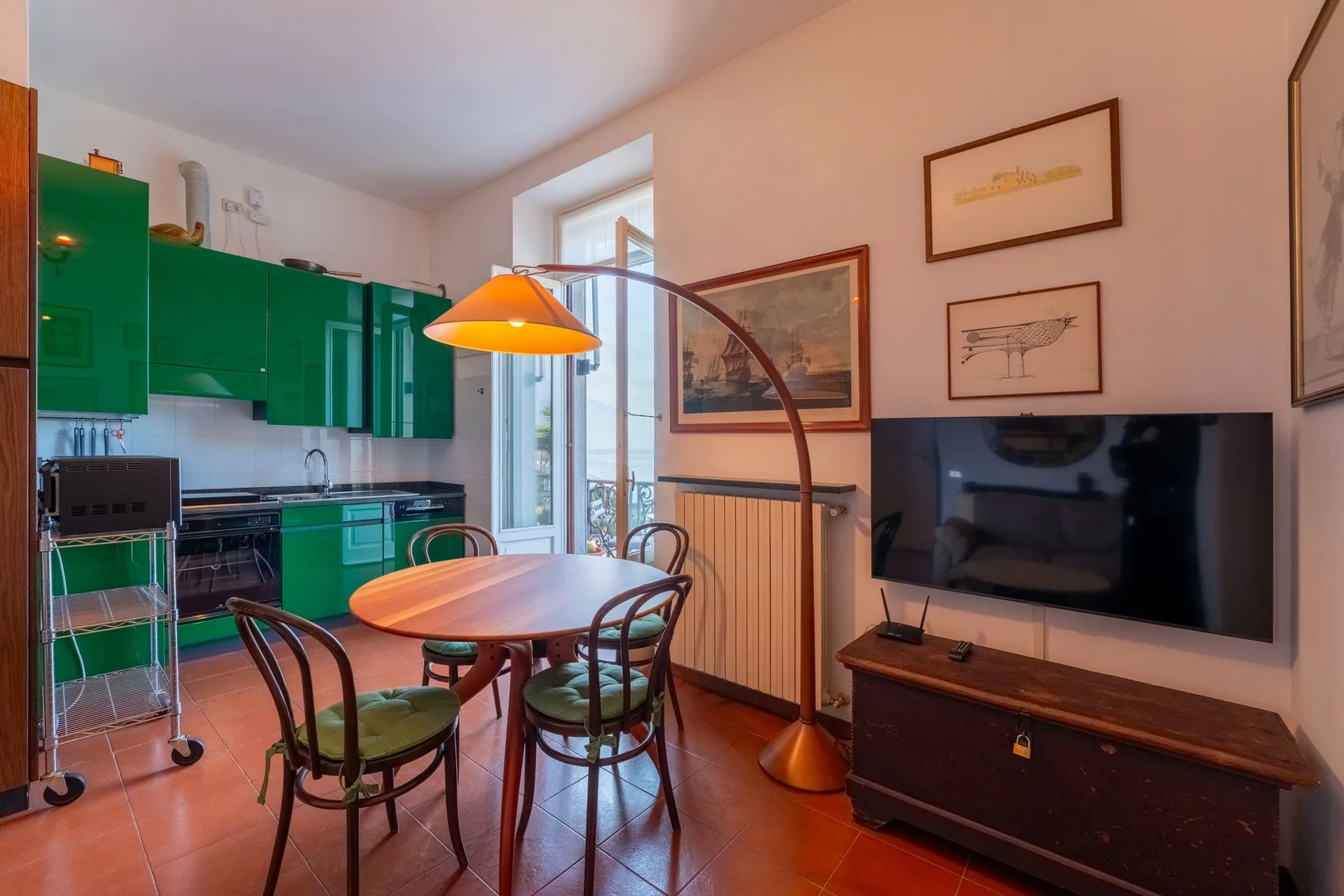 Comedor con una mesa redonda y armarios verdes de cocina.