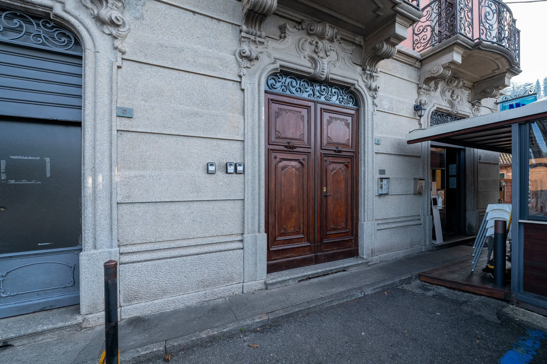 Una entrada ornamentada con una puerta doble de madera y detalles decorativos de piedra.