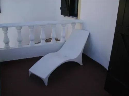 Banco blanco curvo en un balcón con balaustrada.