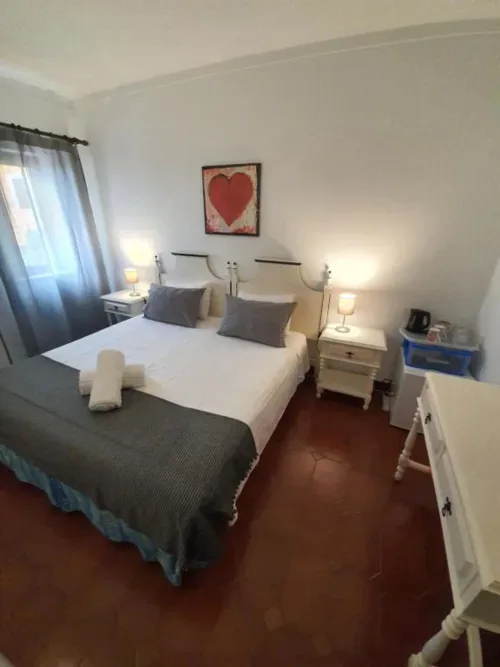 Habitación económica con dos camas individuales, ropa de cama blanca, vistas al jardín y baño compartido.