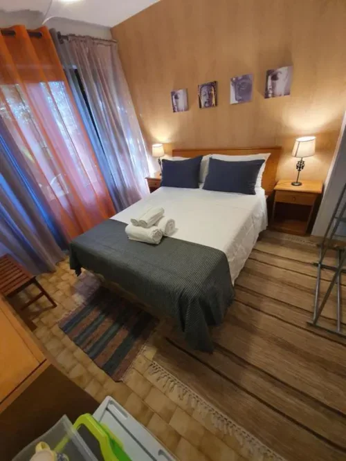 Habitación doble con ropa de cama blanca y muebles de madera.