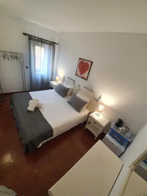 Habitación doble económica con mesitas de noche y una ventana con cortina.