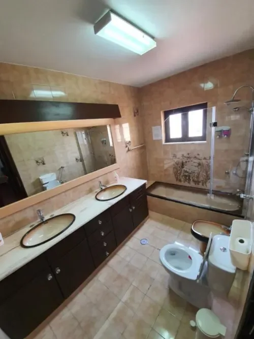 Baño compartido con dos lavabos, inodoro y ducha a ras de suelo.