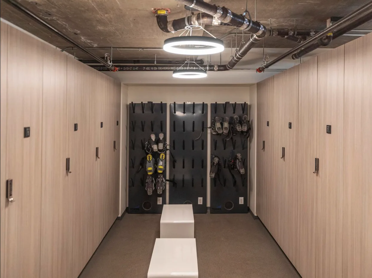 Un cuarto de almacenamiento con filas de armarios claros y paneles oscuros para equipo.