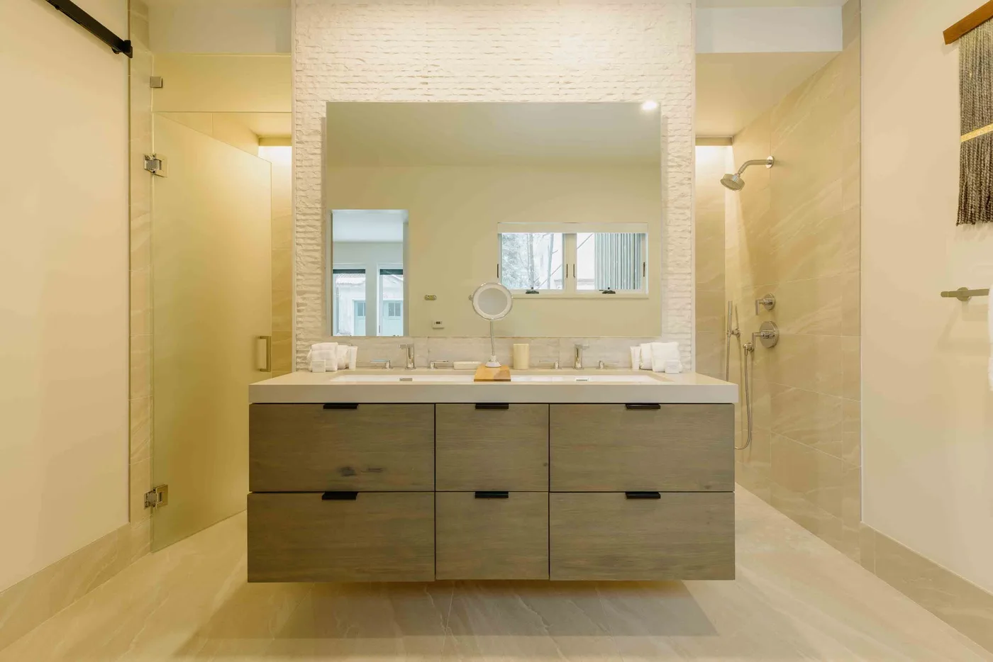 Un baño luminoso con un amplio lavabo bajo un espejo grande.