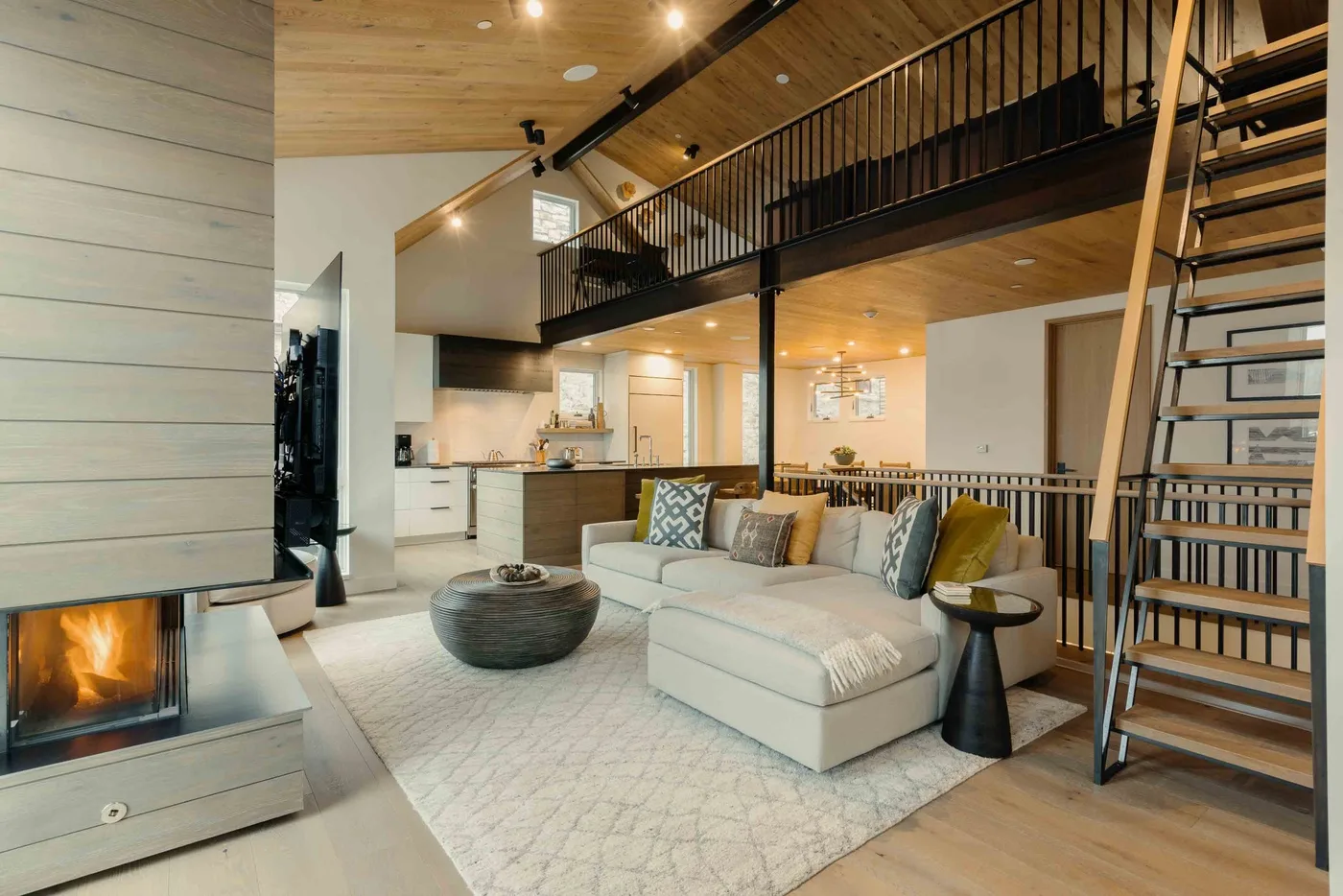 Sala de estar de planta abierta con zona de asientos, chimenea y cocina.