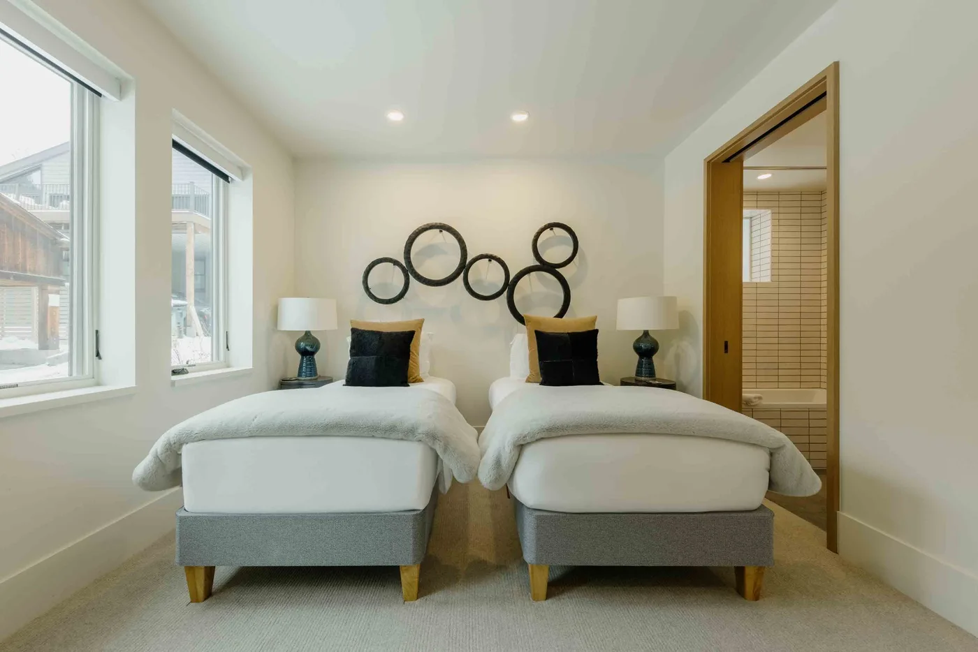 Un dormitorio luminoso con dos camas individuales y adornos circulares en la pared.