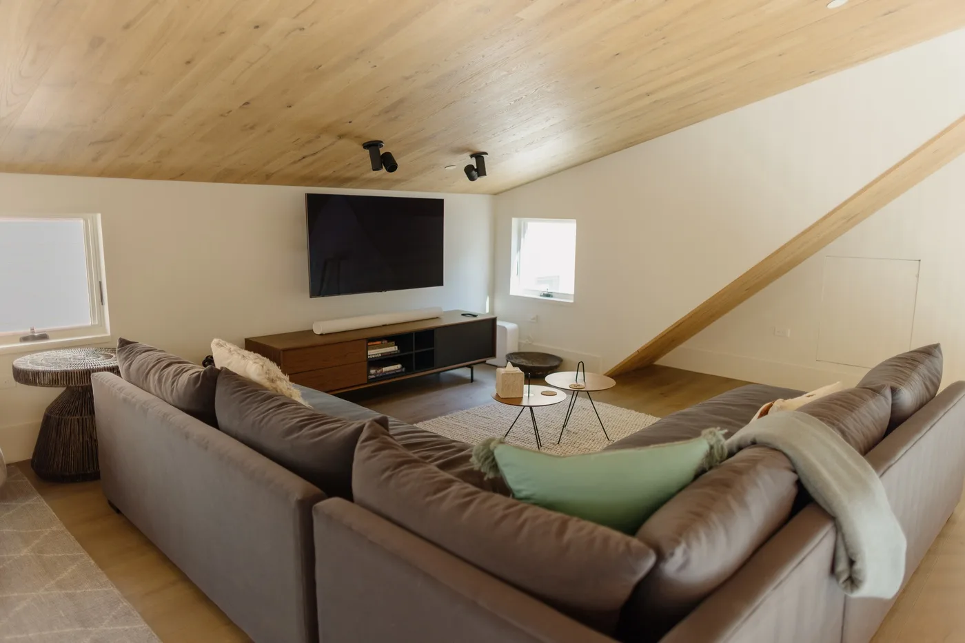 Una sala de estar con asientos frente a un televisor y una mesa de centro.
