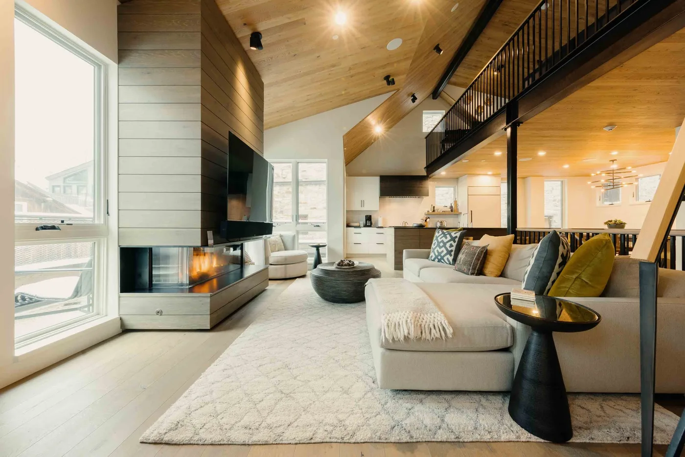 Una sala de estar luminosa con chimenea, asientos y una cocina abierta.