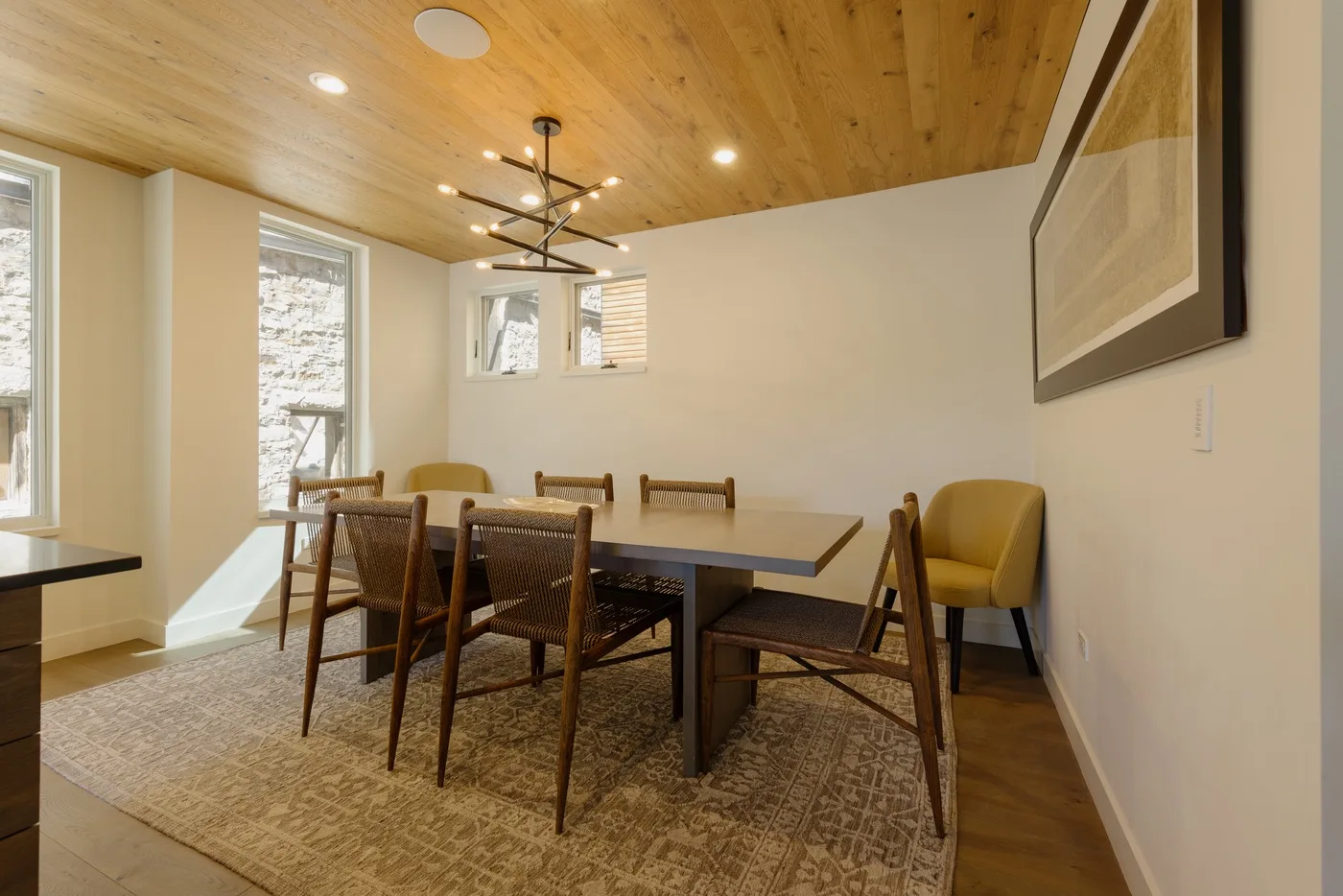 Comedor con una mesa de madera, sillas y una alfombra estampada.