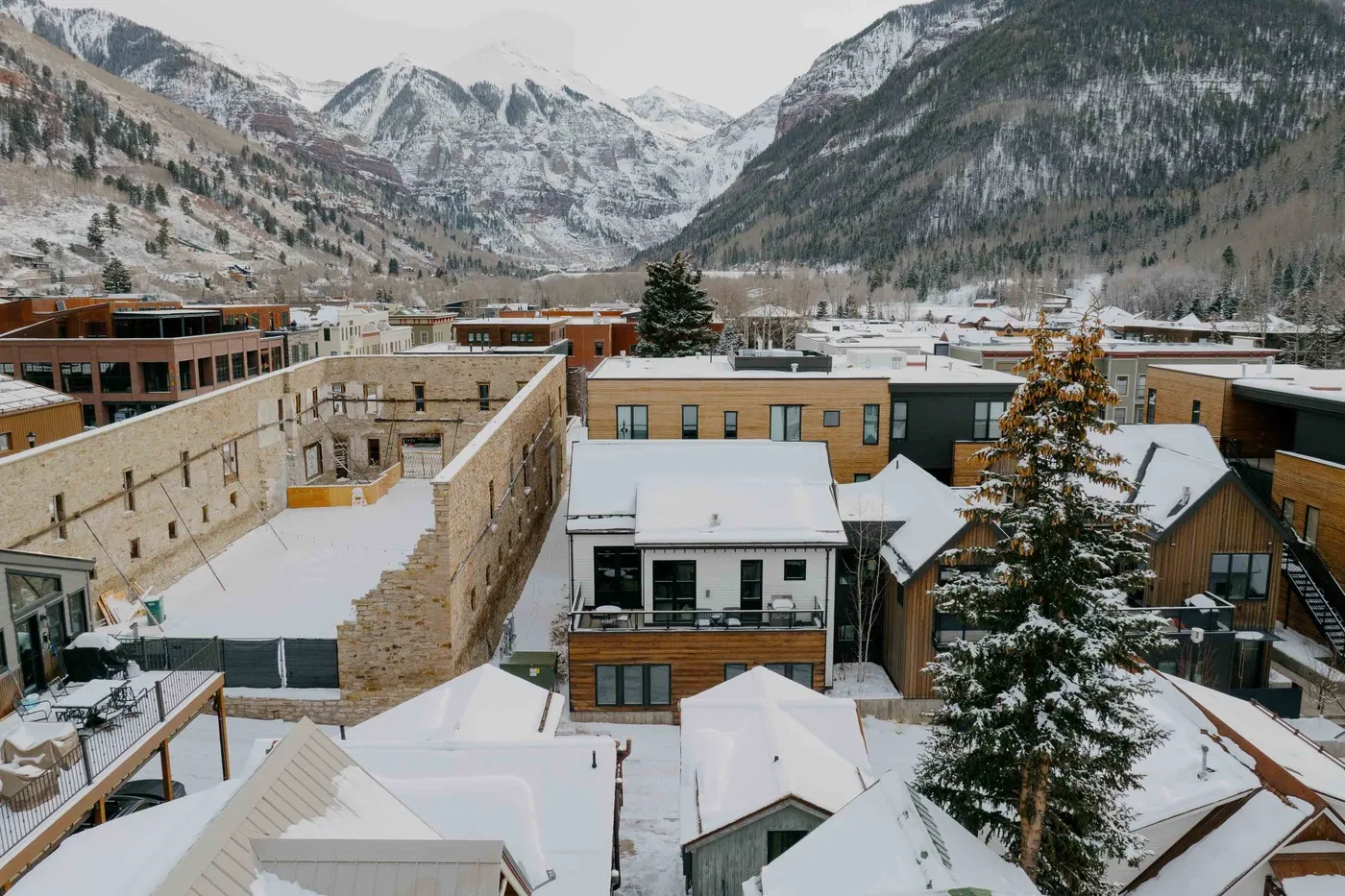 Edificios cubiertos de nieve se encuentran bajo un valle montañoso en invierno.