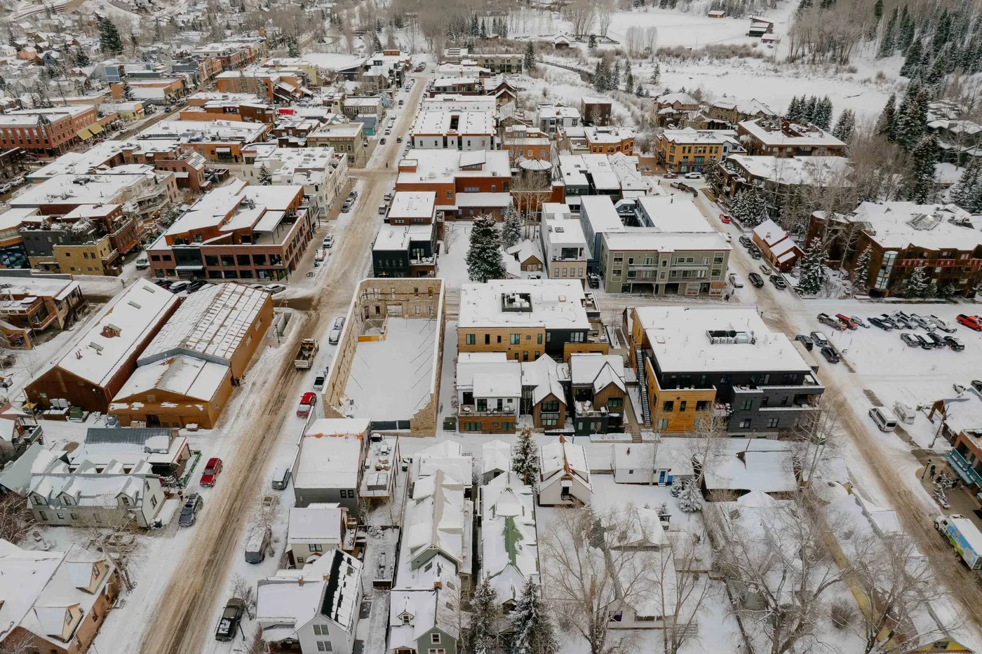 Vista aérea de un pueblo cubierto de nieve, con edificios y calles.