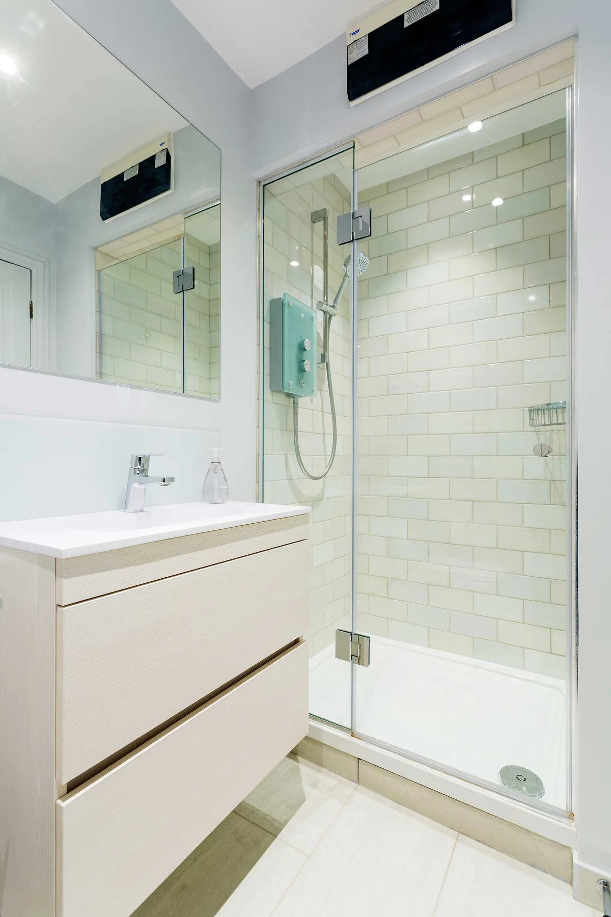 A bright bathroom with a vanity and a glass-enclosed shower.