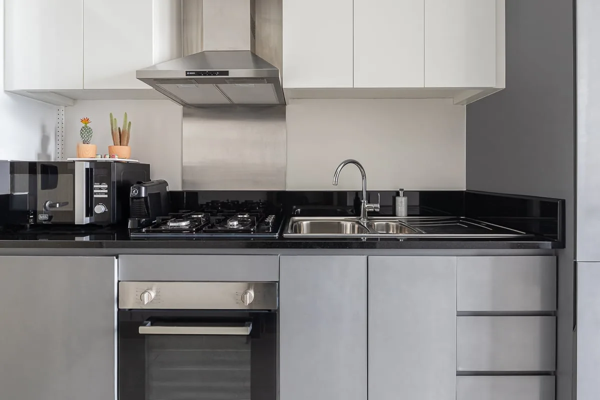 Una cocina moderna con gabinetes blancos, una encimera y un fregadero.