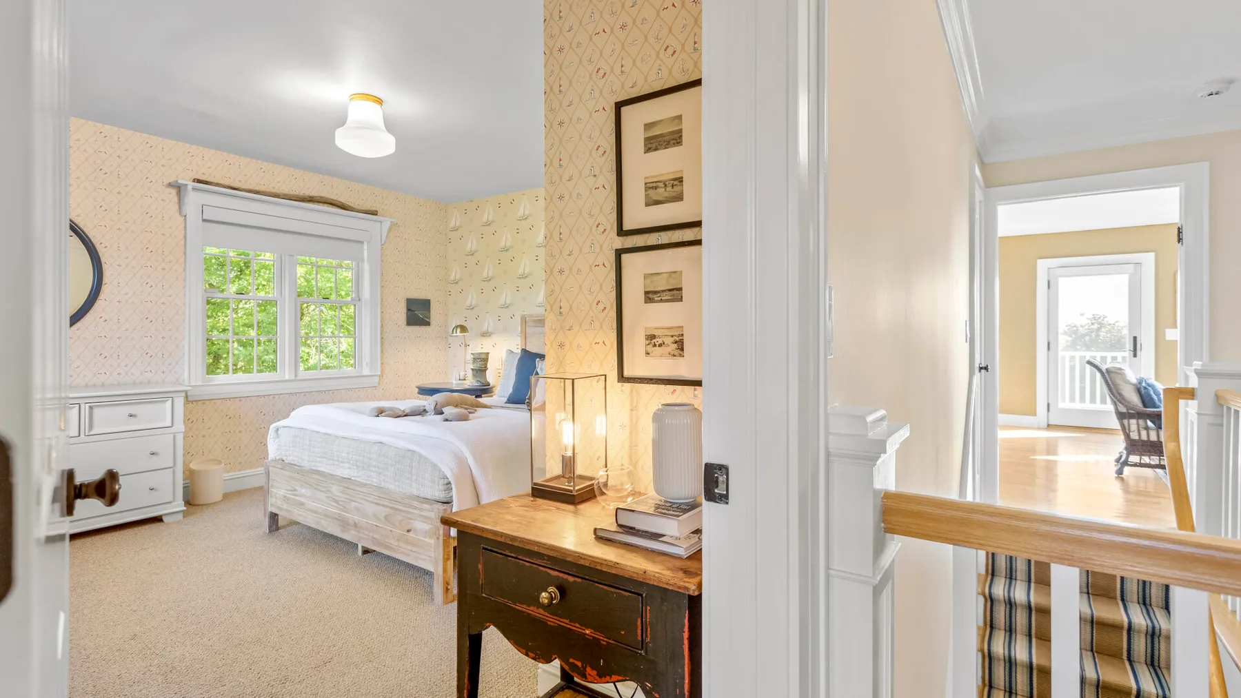 Un dormitorio con una cama junto a una ventana y una mesita de madera.