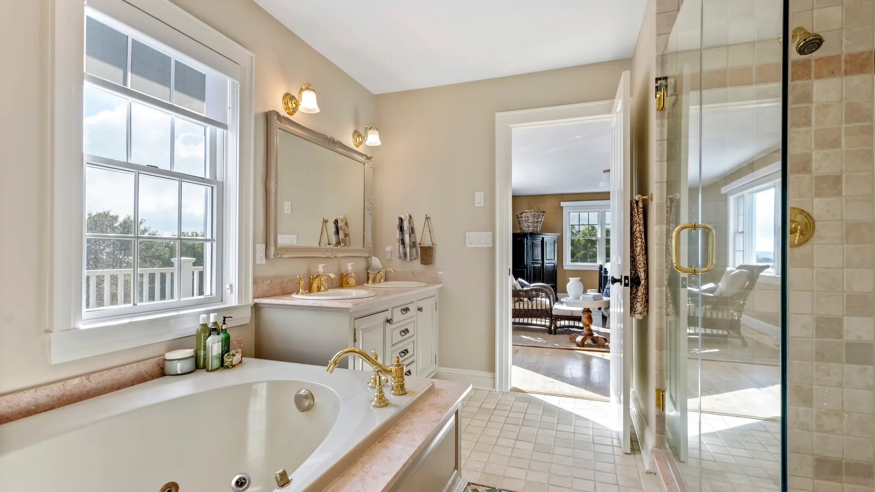 Un baño luminoso con bañera, lavabo y ducha de cristal.