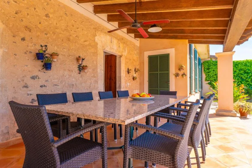 Una zona de comedor exterior cubierta con una mesa larga y sillas.
